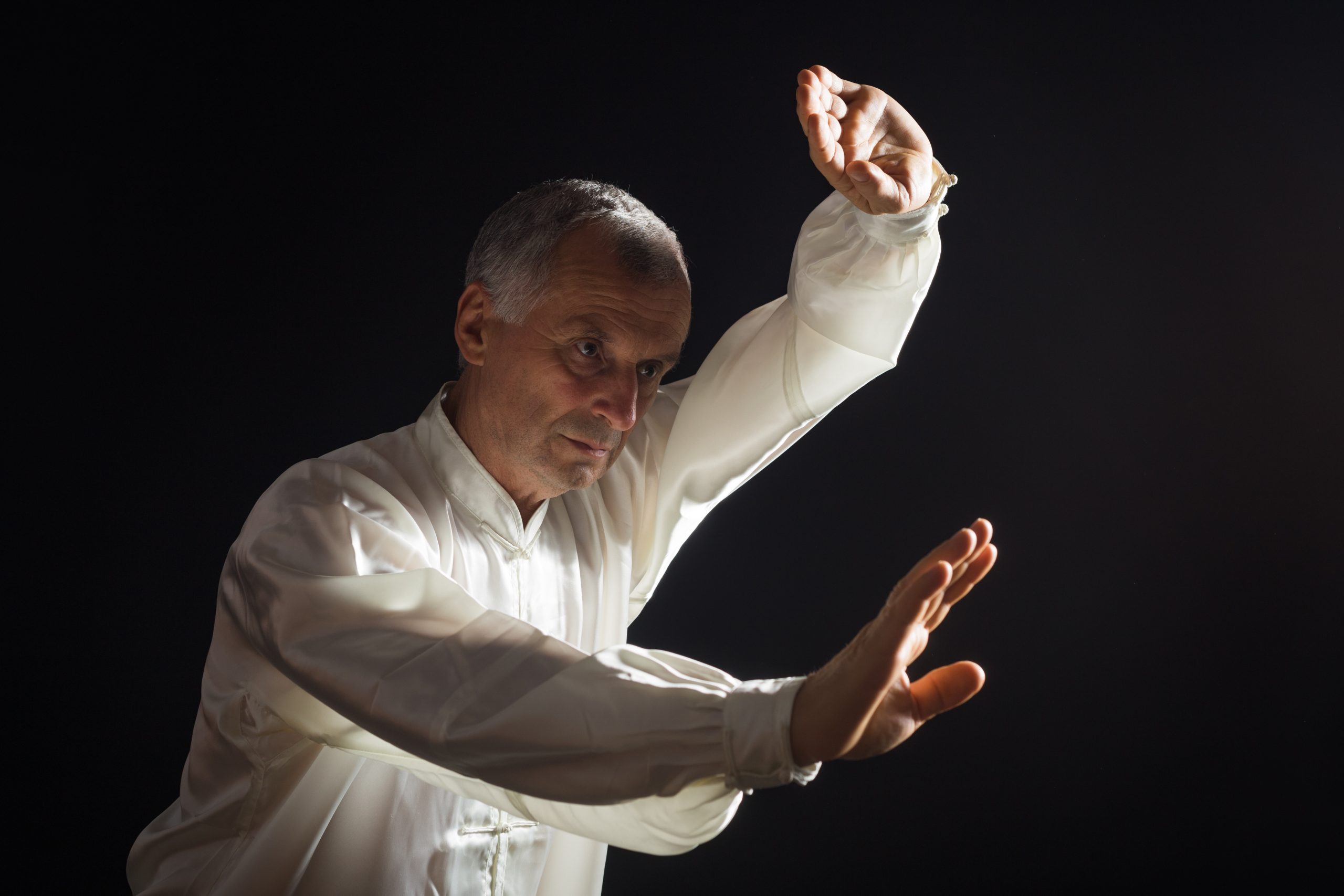 Senior man enjoys exercise Tai Chi indoor.